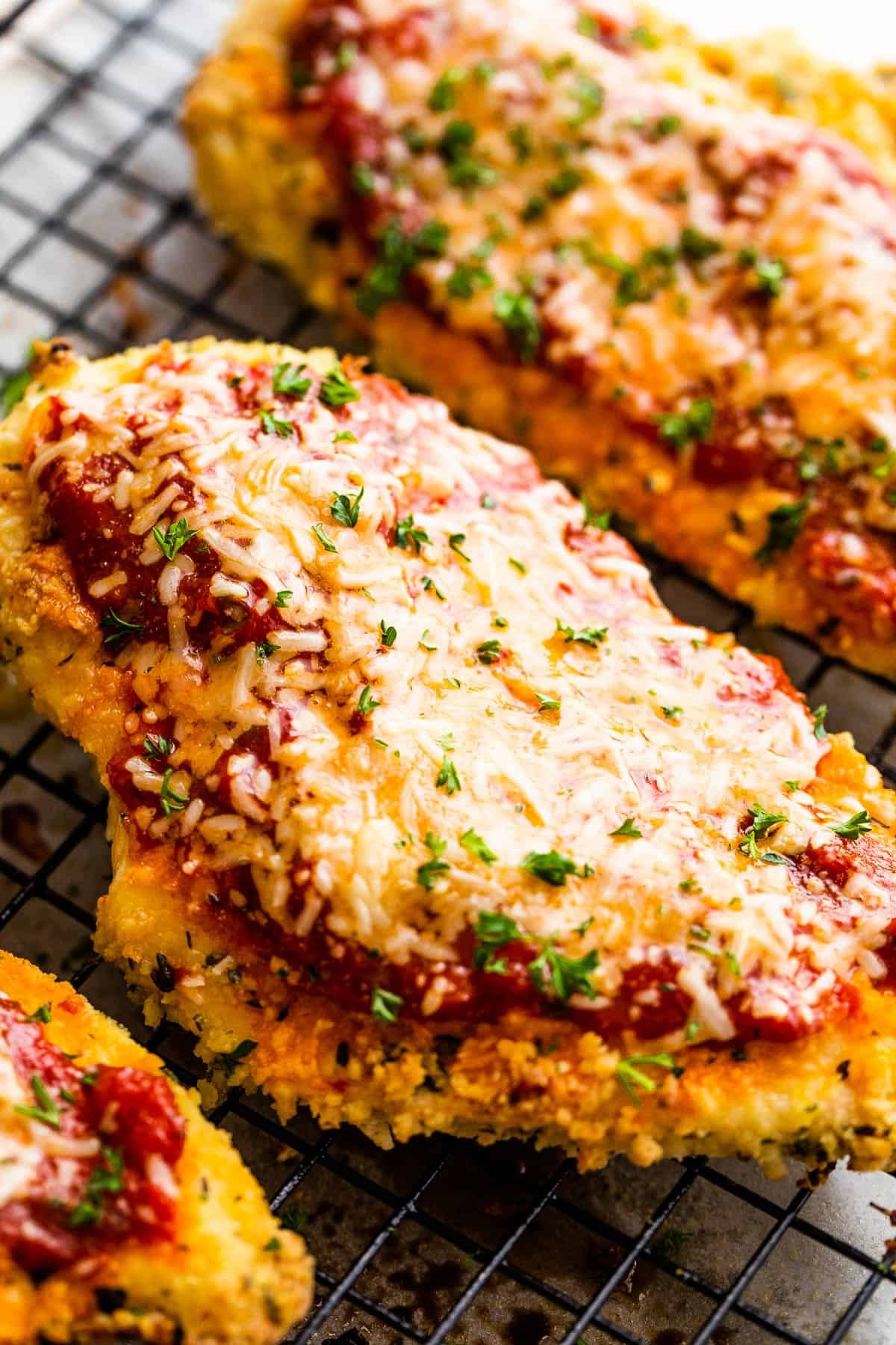 A Close-Up Shot of a Piece of Chicken Parmesan on Top of a wire rack