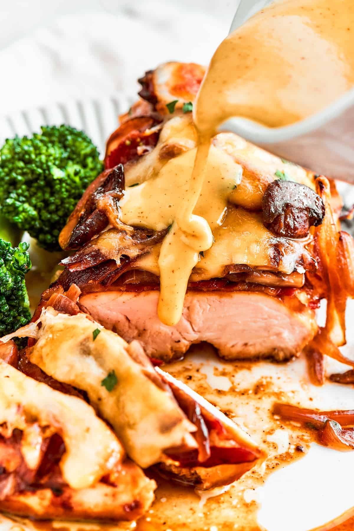 A thick stream of vivid yellow honey mustard sauce is added to a plate of Alice Springs chicken.