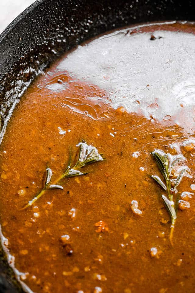 apple cider glaze cooking in a black skillet
