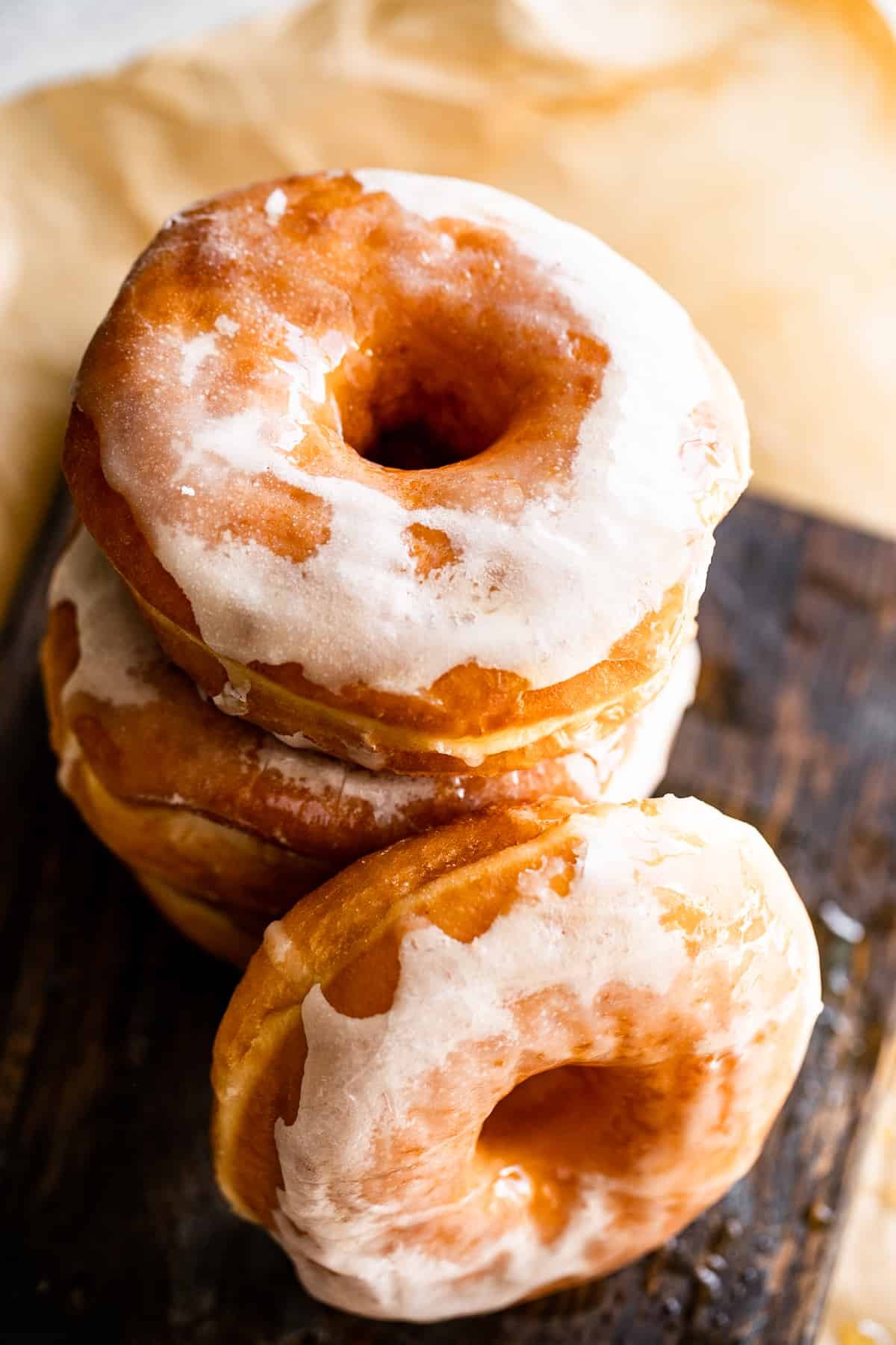overhead shot of stacked up baked donuts set on a brown backdrop.