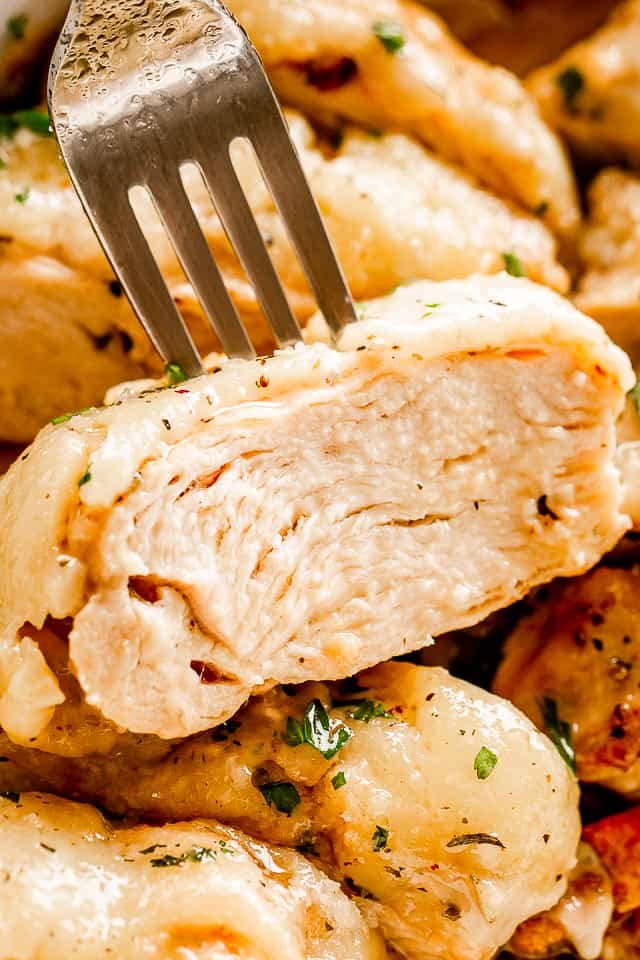 close up view of a fork set through a slice of chicken breast