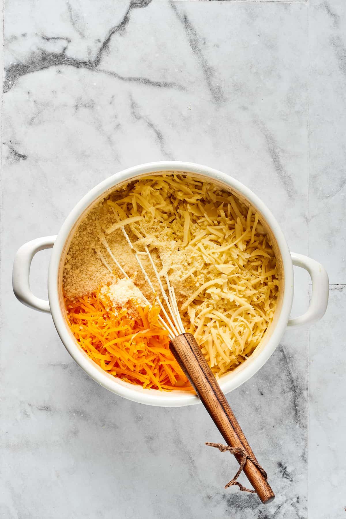 Stirring cheese and seasonings into a cream sauce.