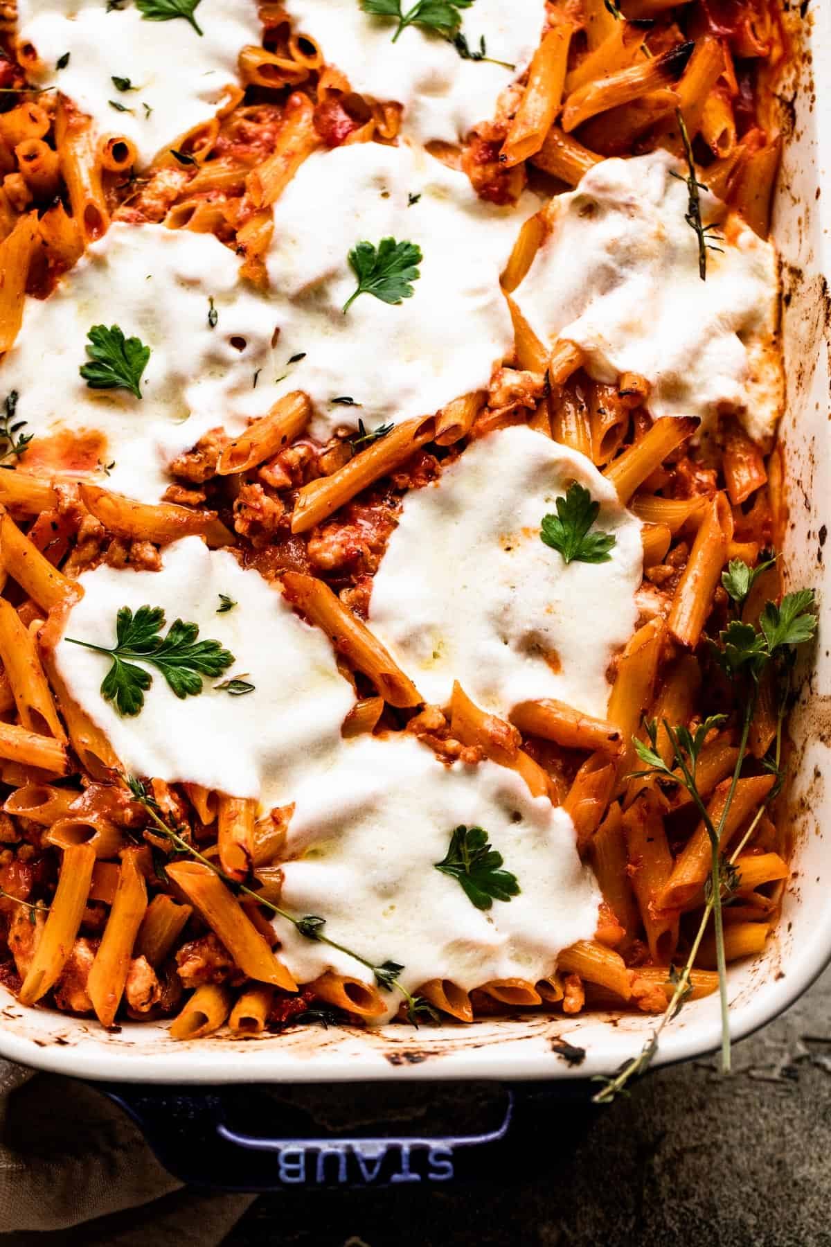 overhead close up shot of a baking dish with Baked Penne Alla Vodka topped with melted mozzarella cheese.