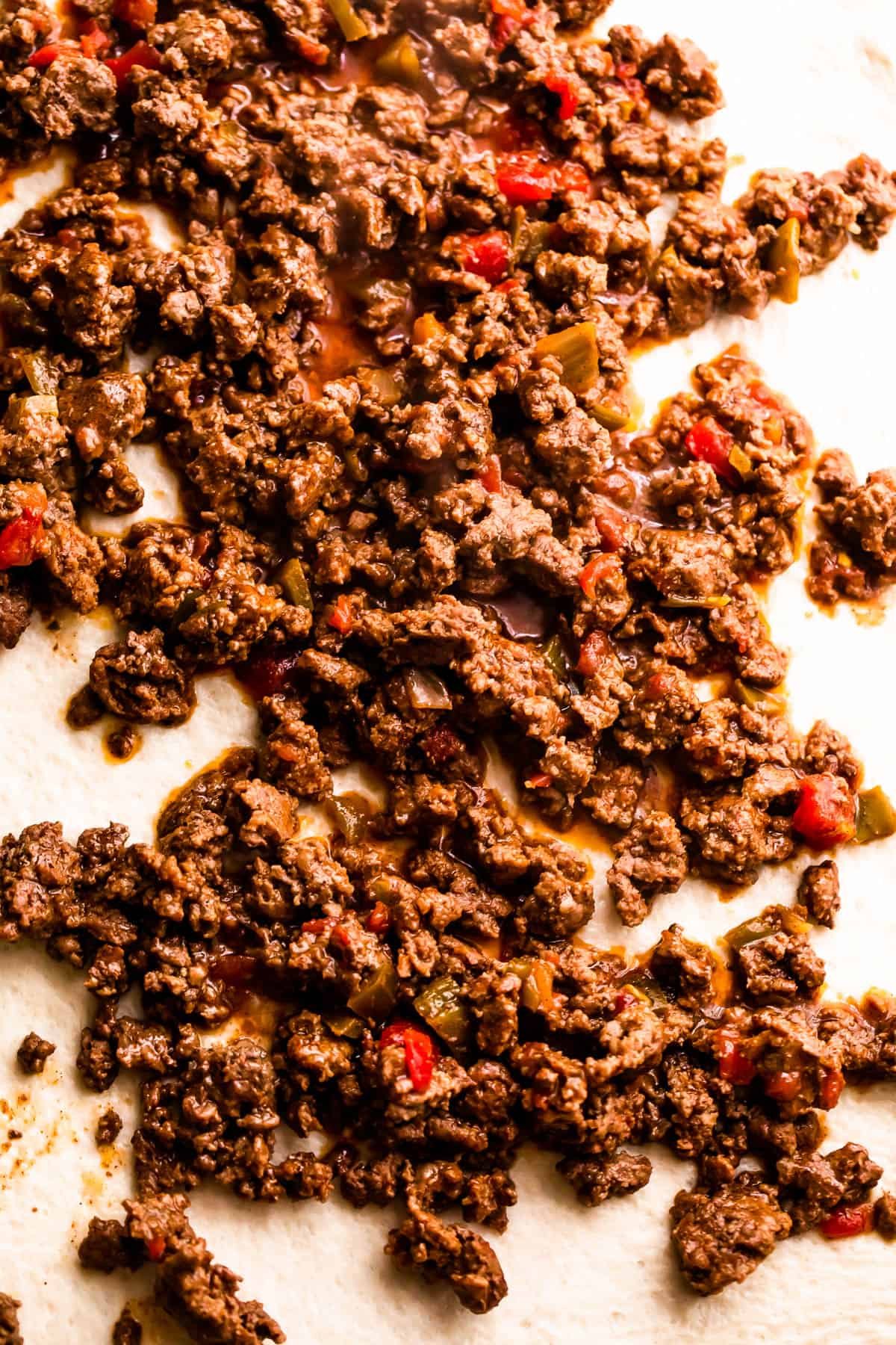 ground beef sprinkled over pizza dough.
