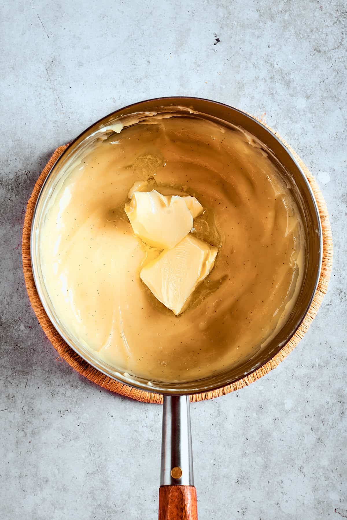 Stirring butter into warm pudding.