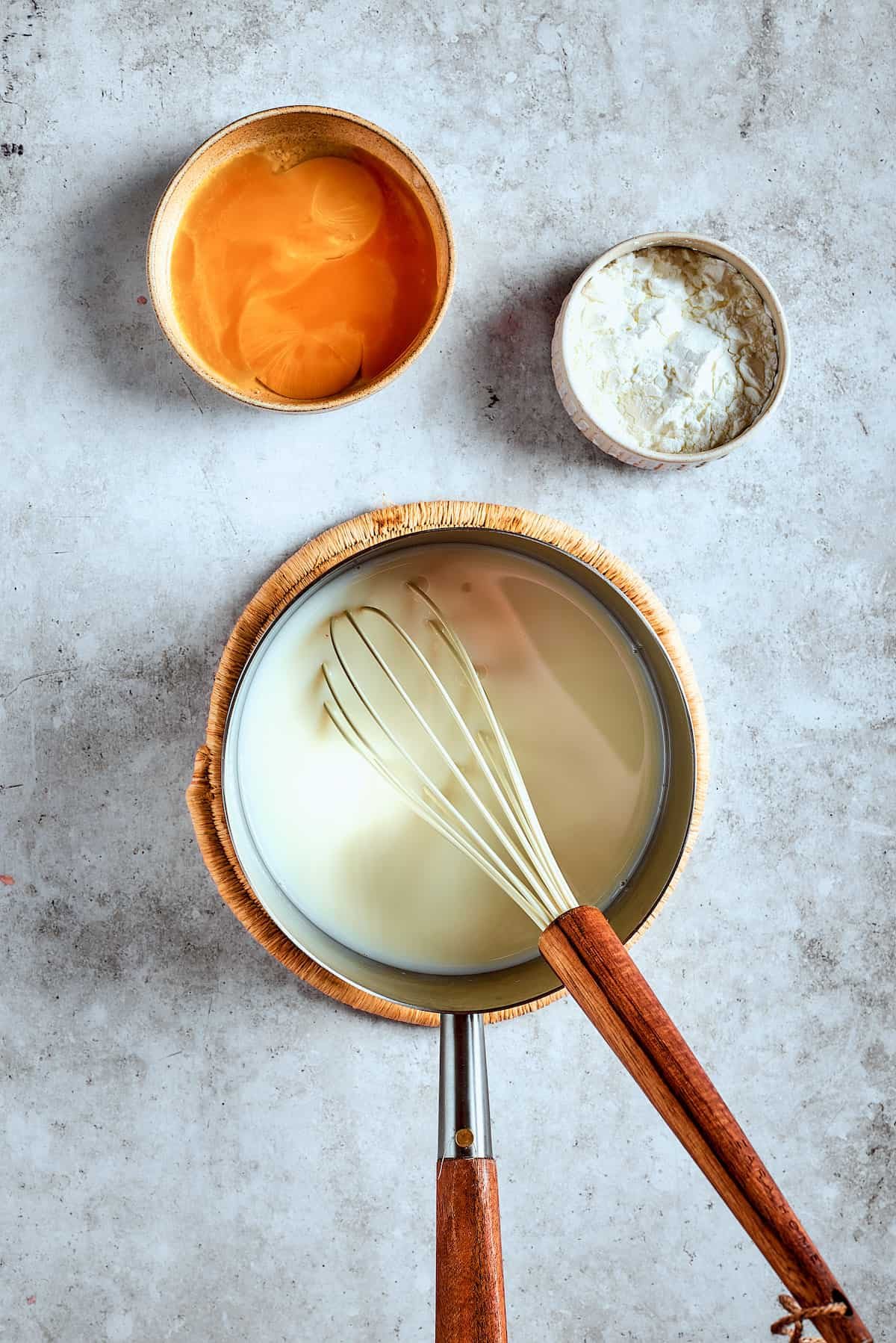 whisking milk and sugar in a saucepan.