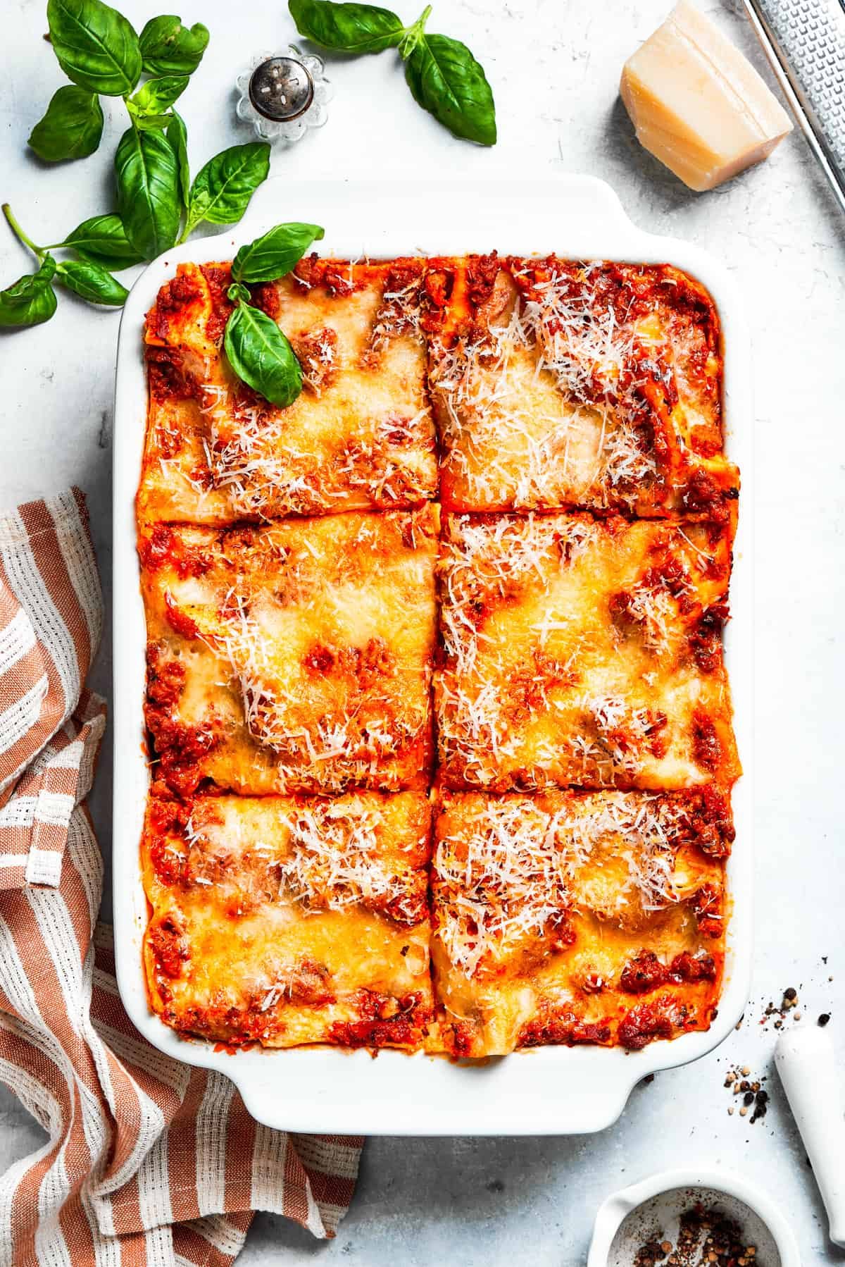 A pan of beef lasagna cut into squares.