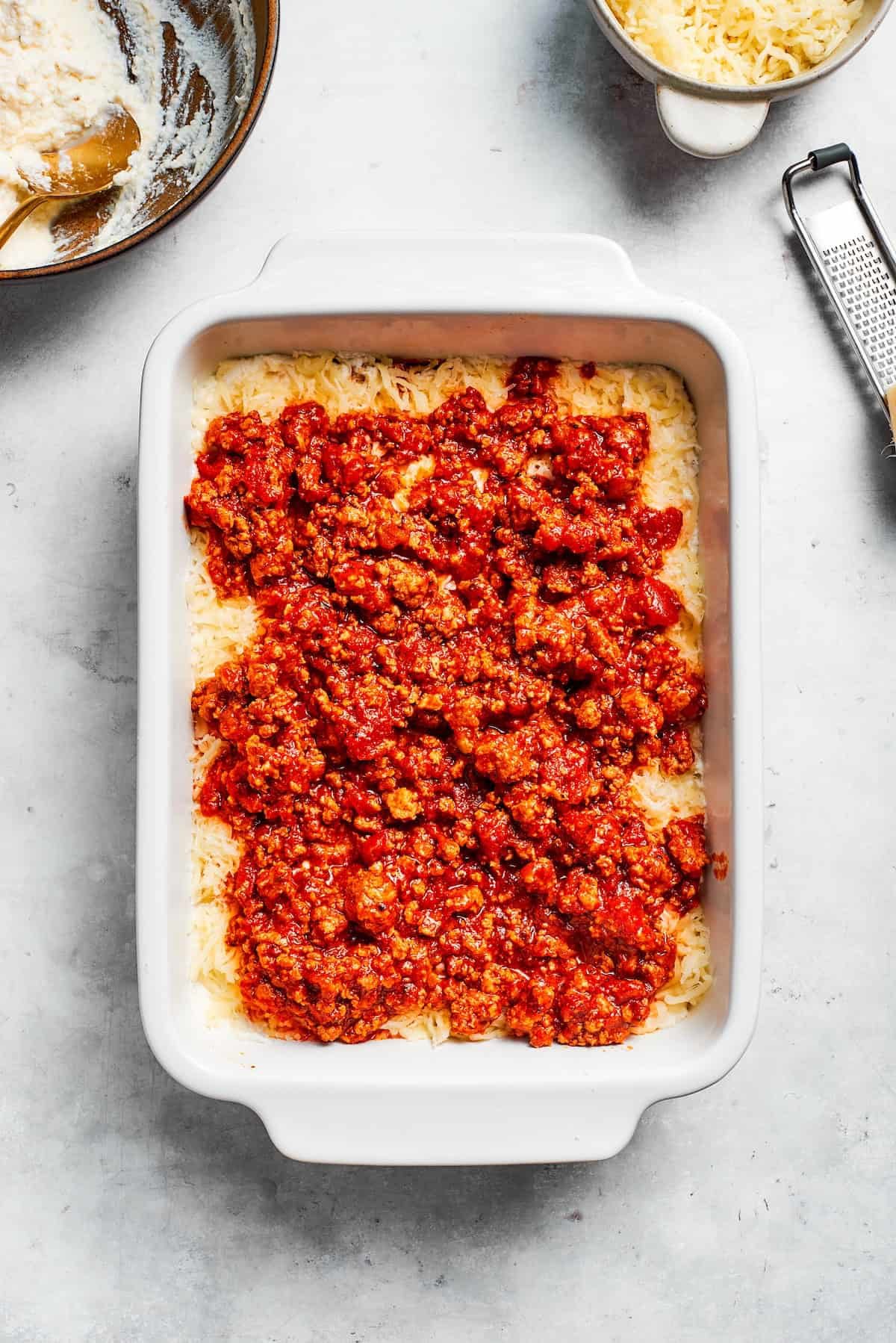 Meat sauce is added to beef lasagna.
