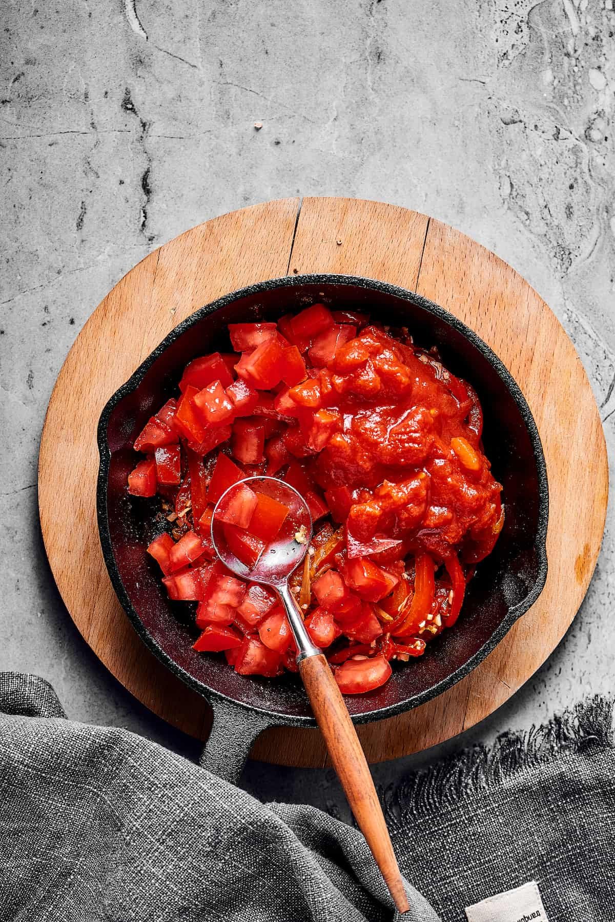 Tomatoes, bell pepper, and onion in a skillet.