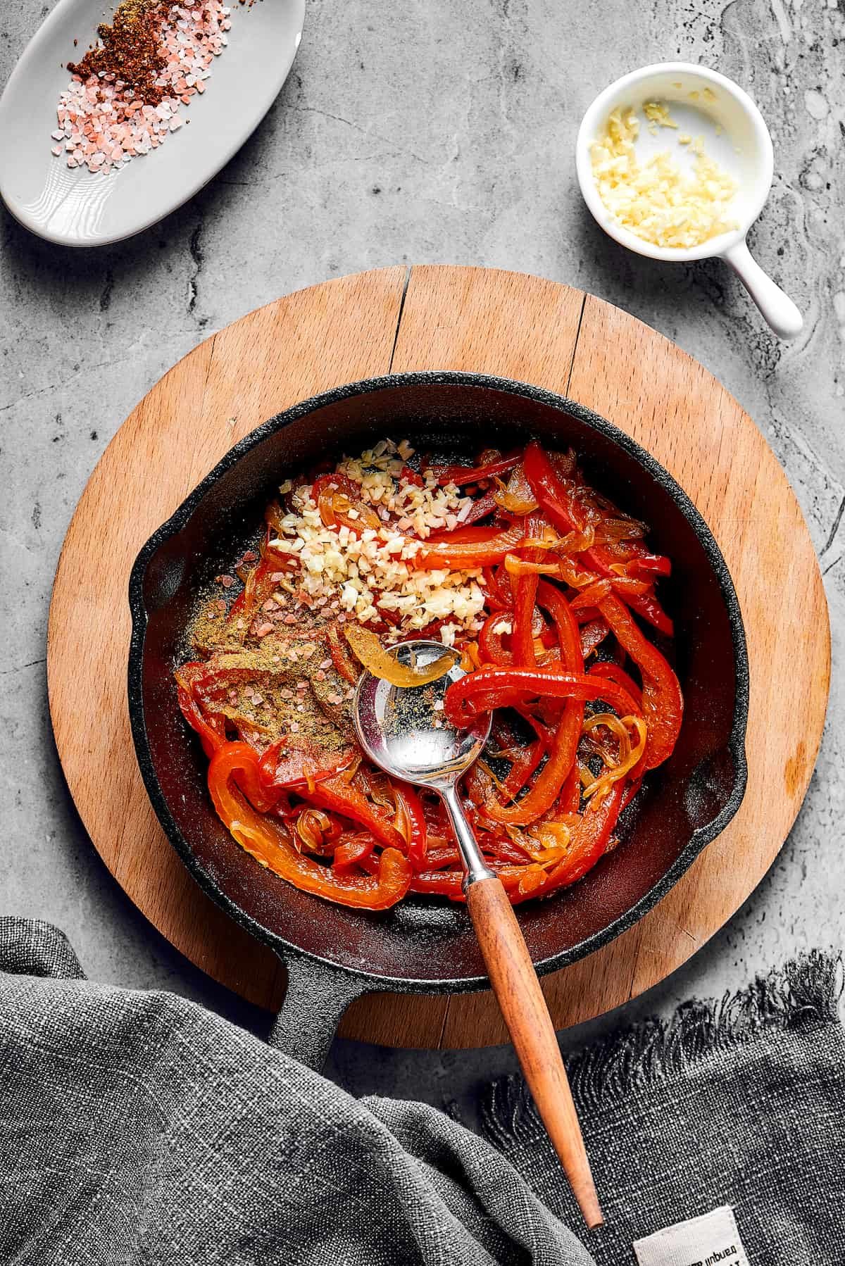 Bell peppers, seasonings, and garlic in a skillet.