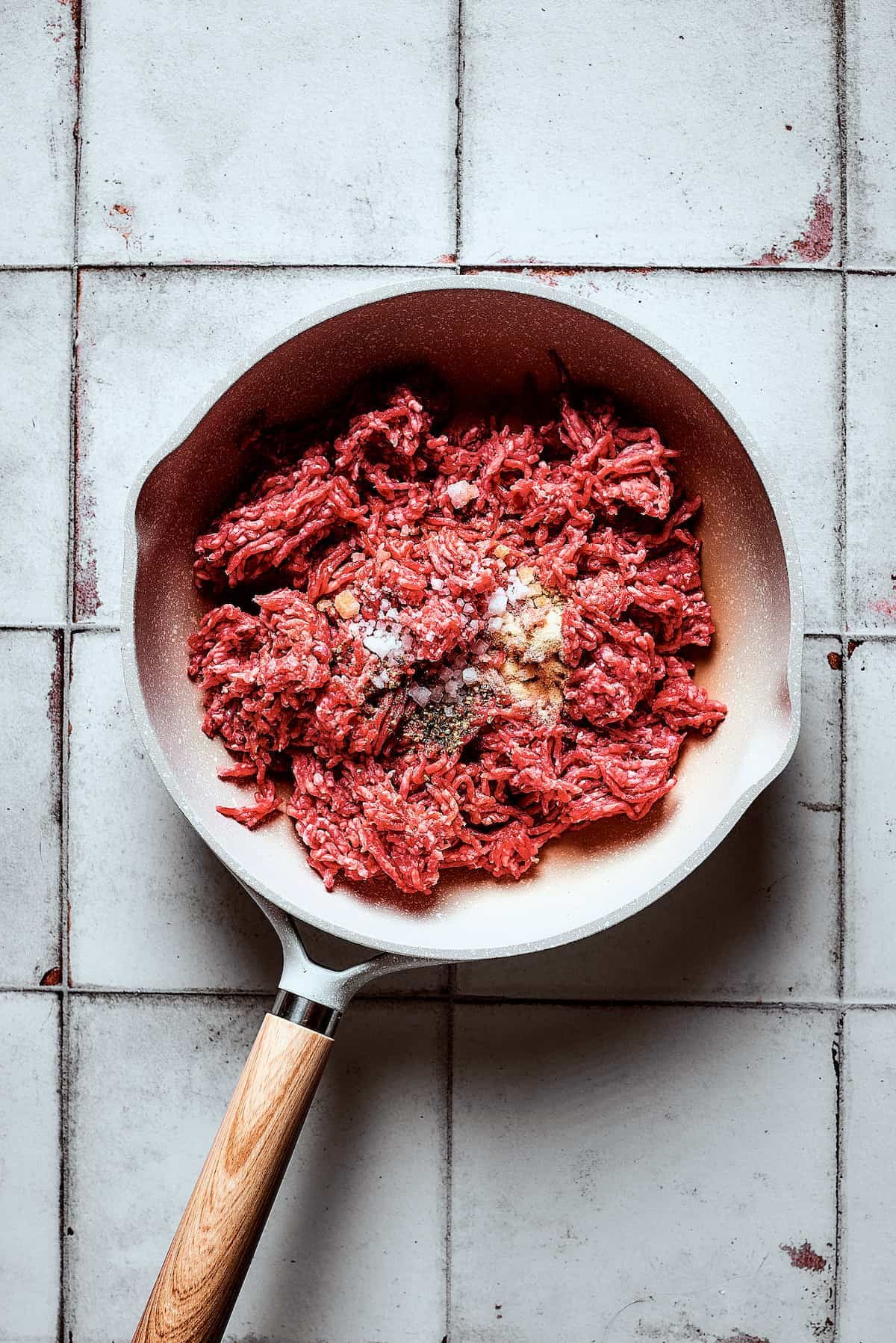 Cooking ground beef and seasonings in a skillet.