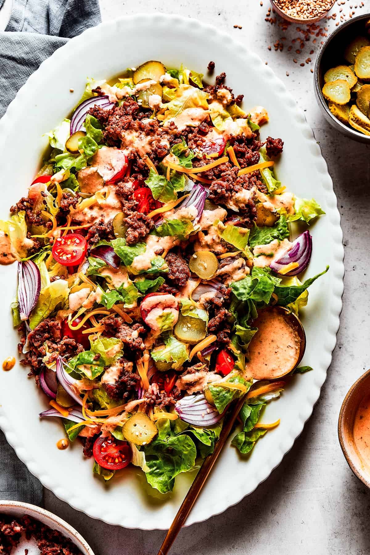 Overhead image of a Big Mac salad served on an oval white platter.