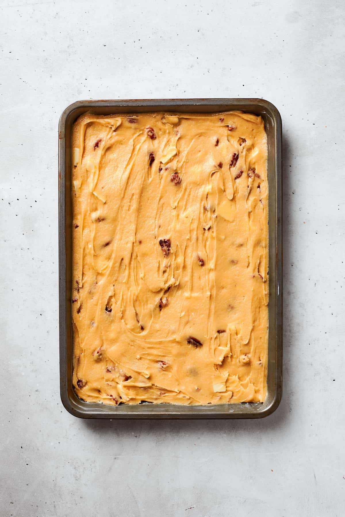 Blonde brownies batter is spread into a baking pan.