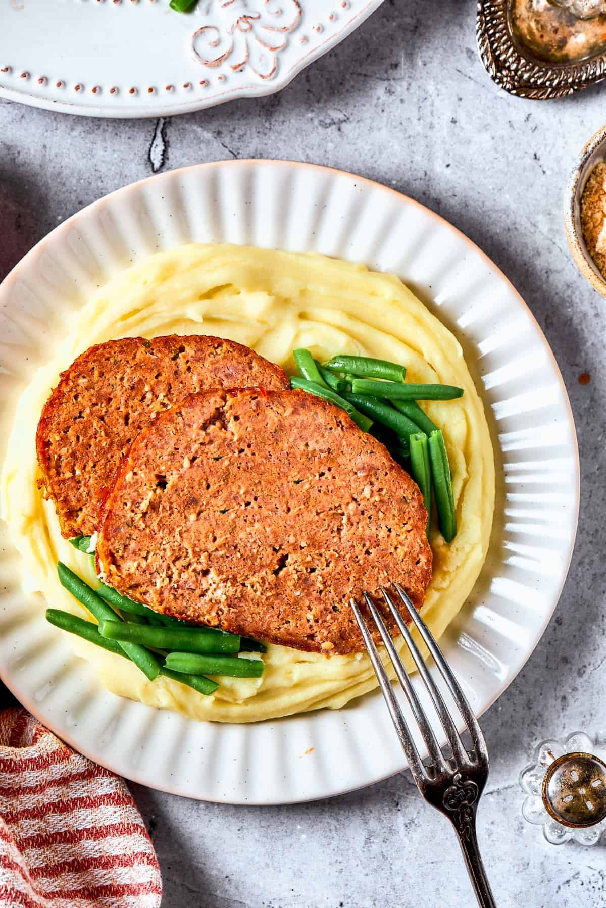 Two slices of brown sugar meatloaf served over mashed potatoes.