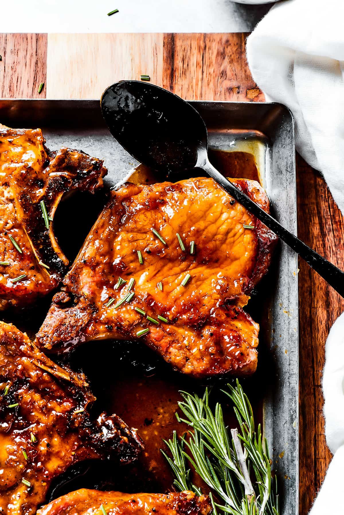 Spooning sauce over pork chops.