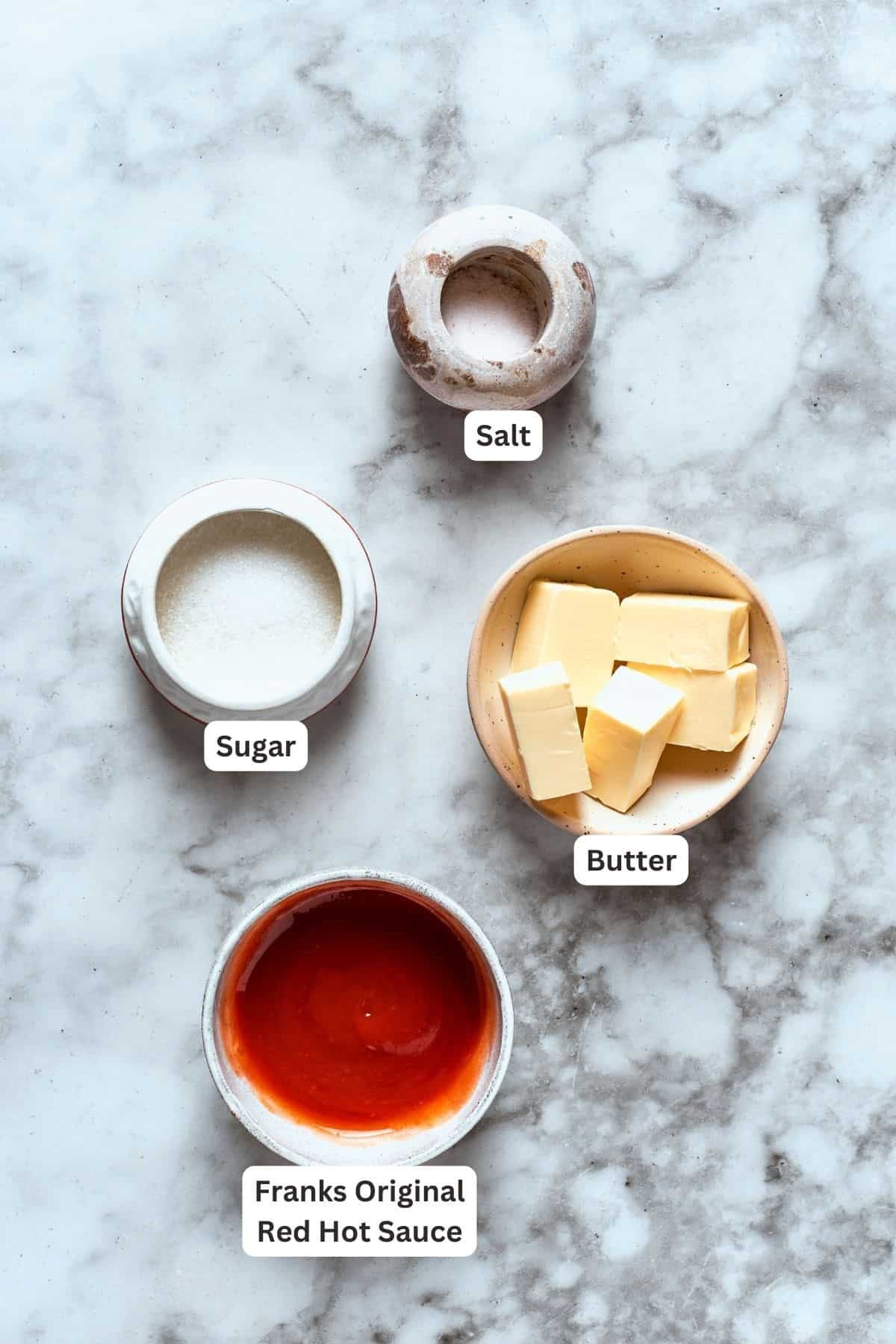 Ingredients for buffalo wings sauce are labeled and portioned: butter, sugar, salt, hot sauce.