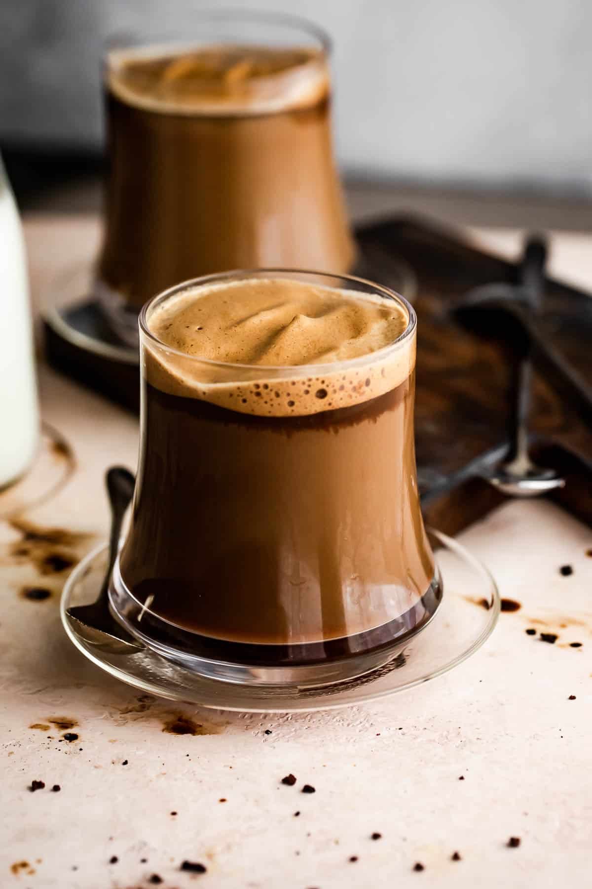 Image of two glass coffee mugs filled with coffee.