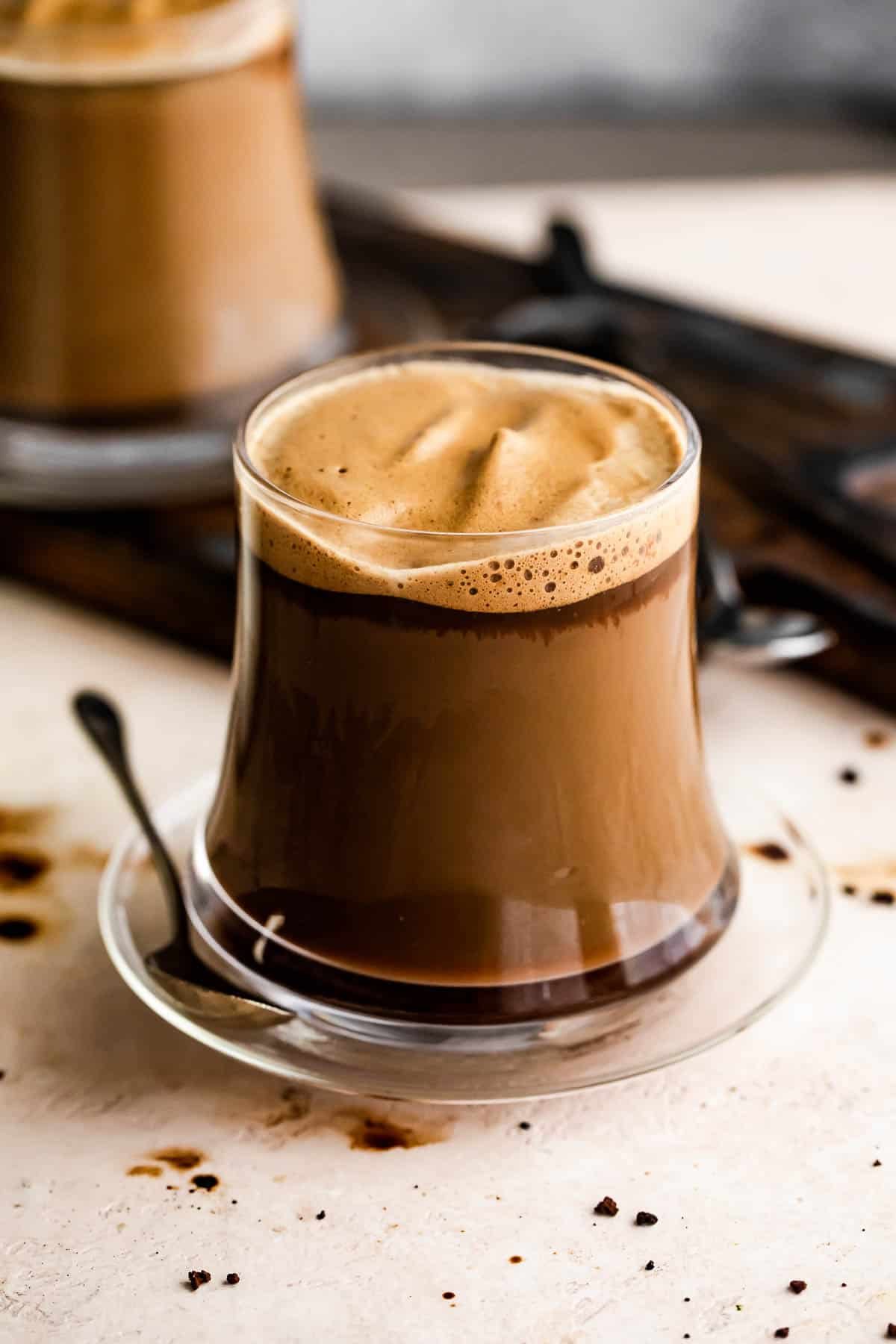 Homemade Macchiato served in a glass mug.