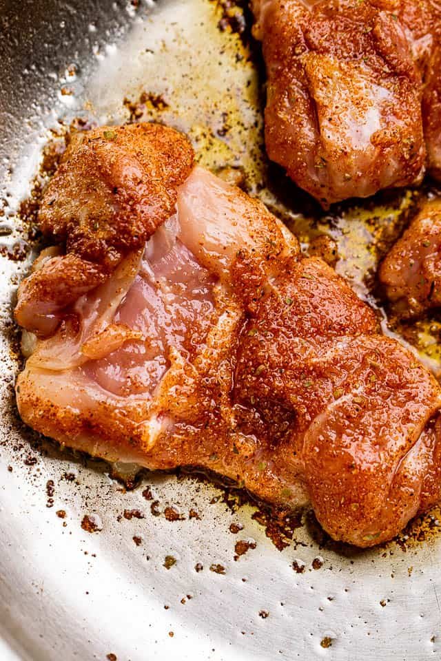 raw chicken thighs rubbed with cajun seasoning