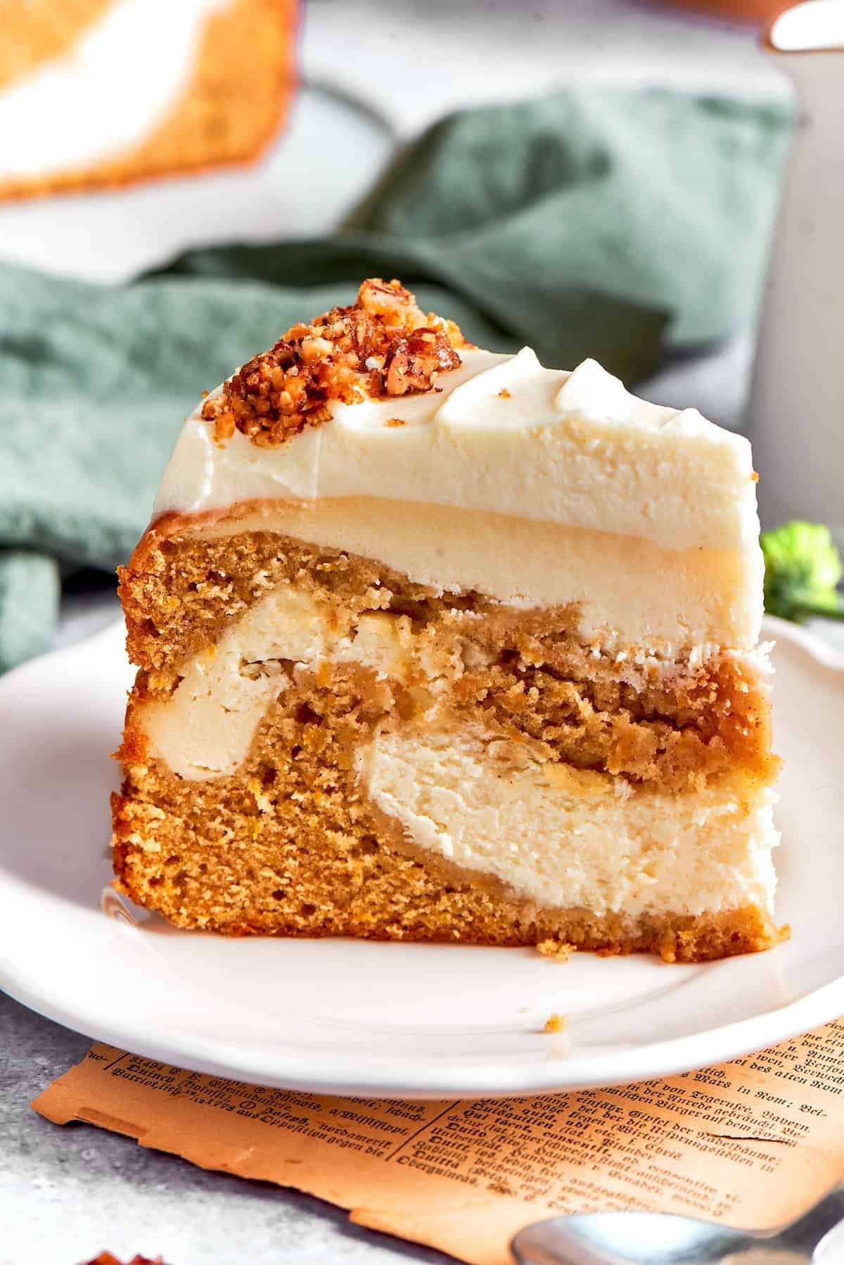 A thick slice of carrot cake cheesecake on a plate.