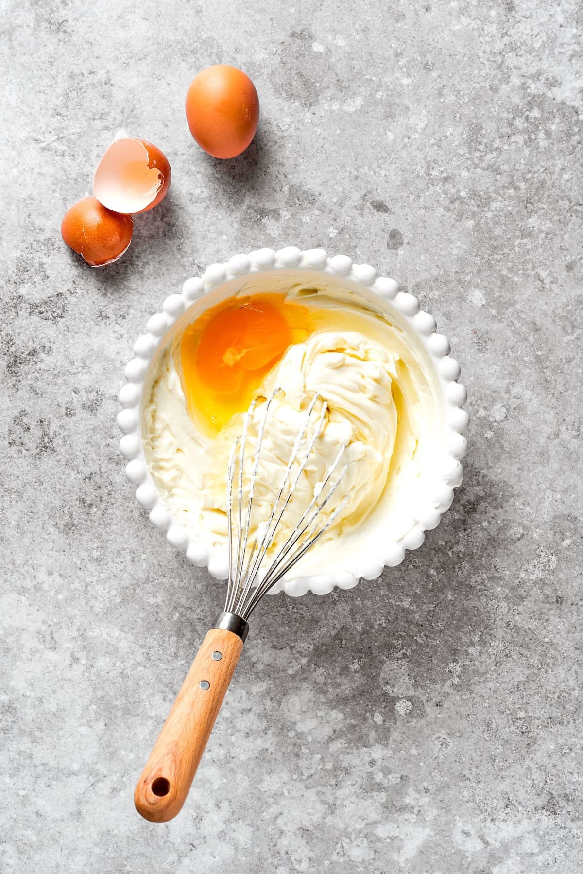 Eggs and cream cheese whisked in a bowl.