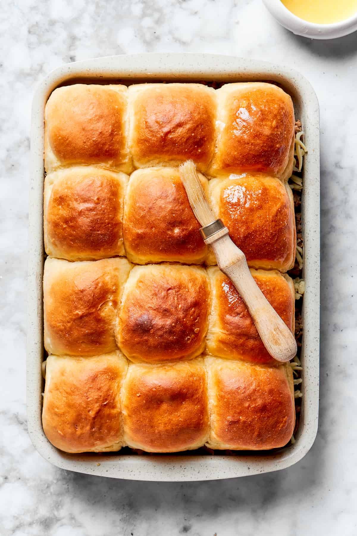 Garlic butter is brushed on top of the rolls.