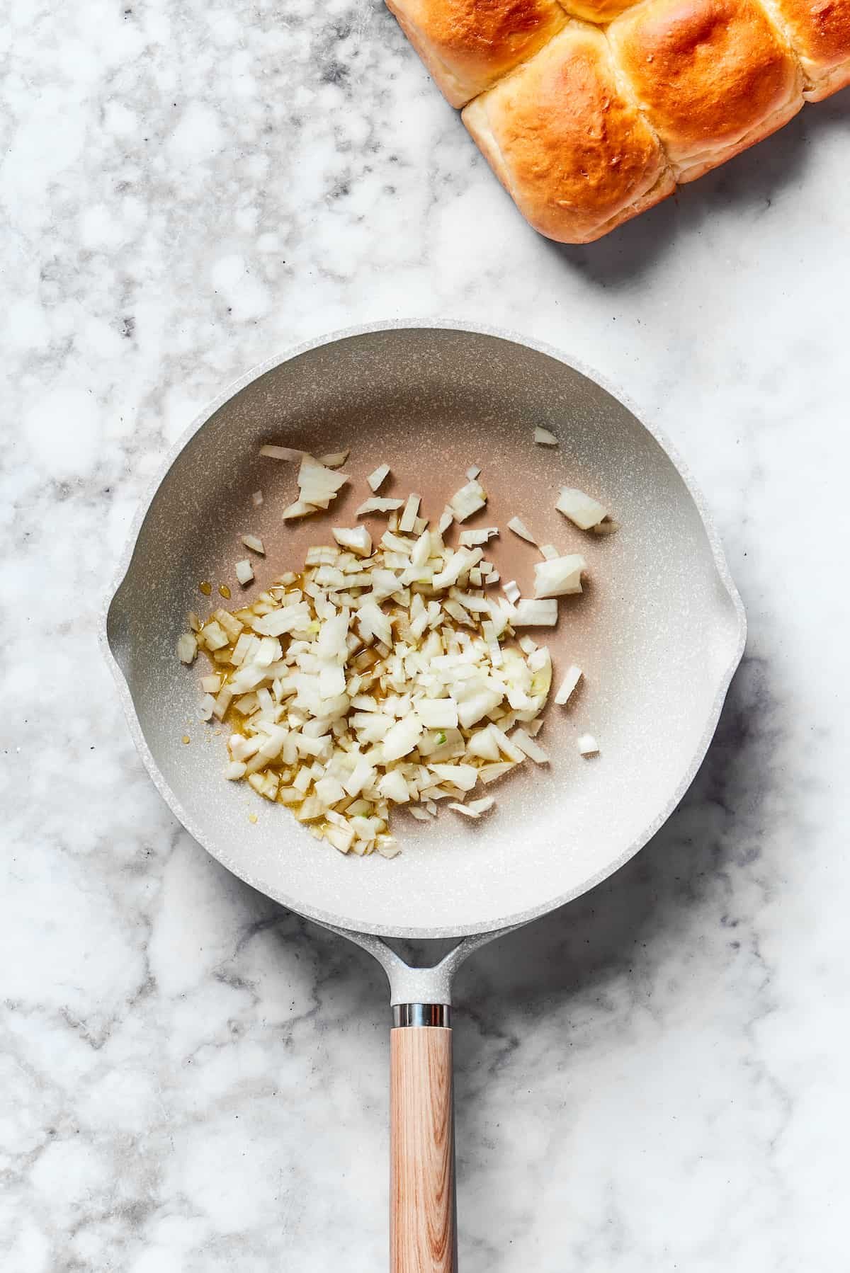 Chopped onion cooks in a skillet.
