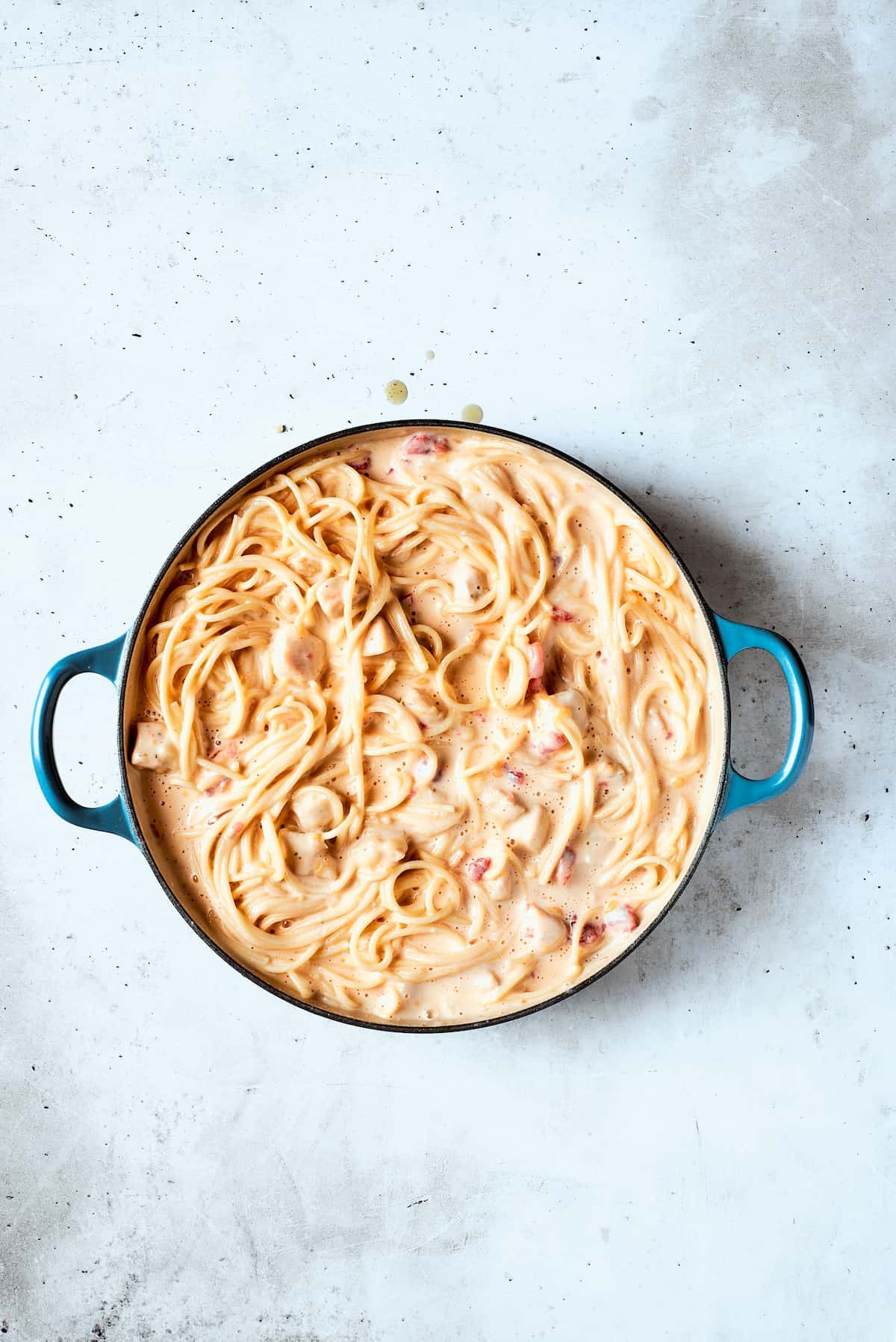 The chicken and spaghetti are incorporated into te sauce.