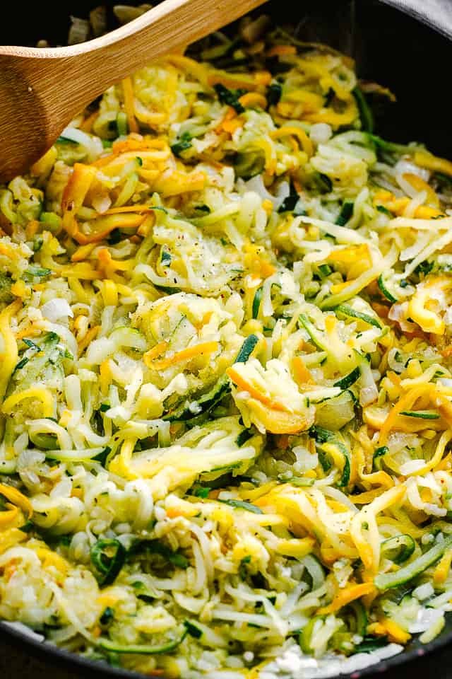 sauteeing spiralized zucchini in a black frying pan