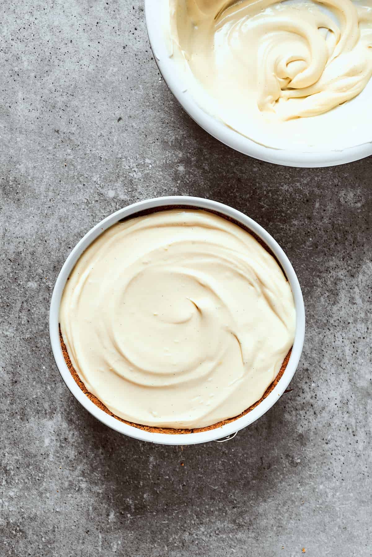 Spreading cheesecake filling into a prepared crust.