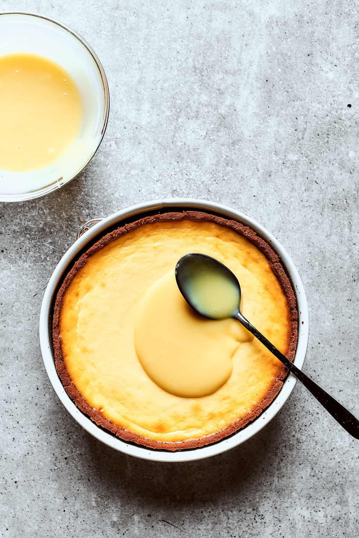 Spreading white chocolate ganache over cheesecake.