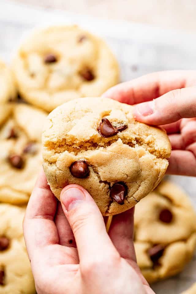 Breaking a cookie apart with your hands.