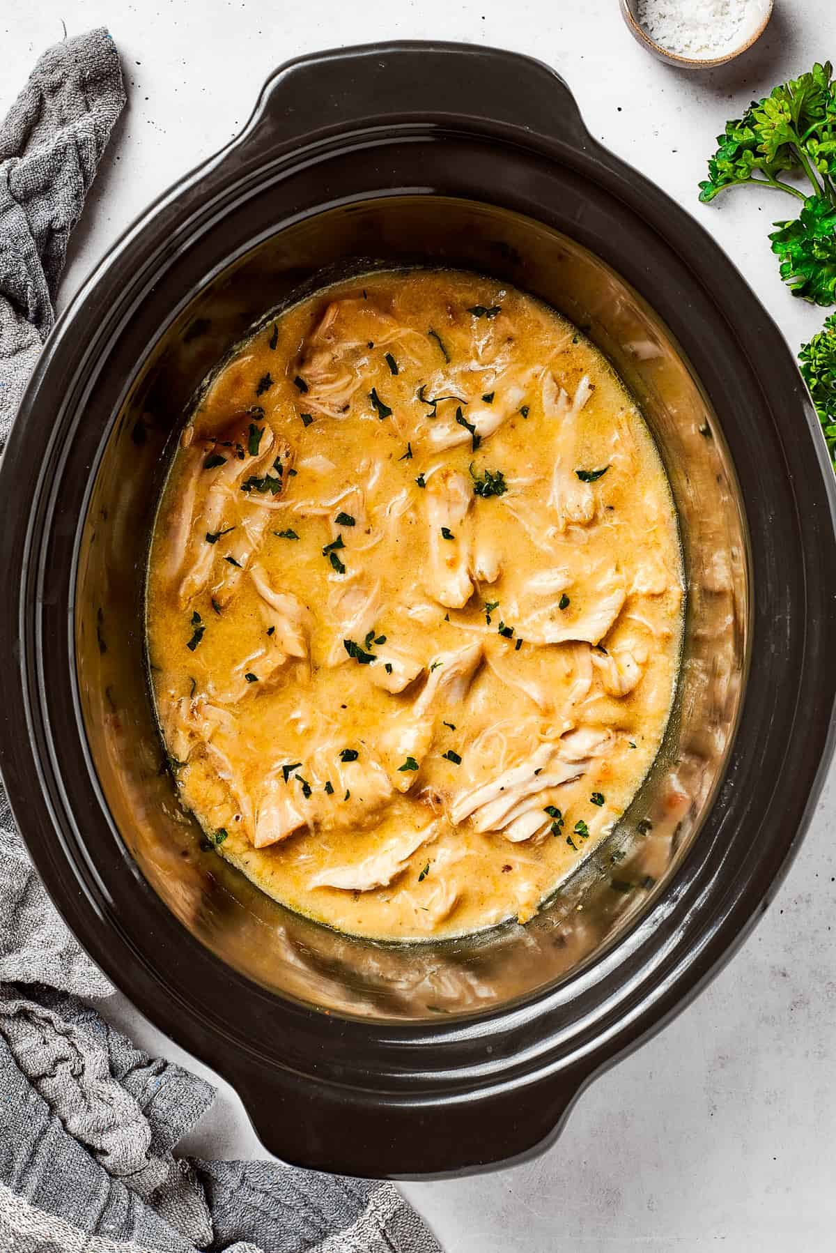 Chicken and gravy cooking in a slow cooker.