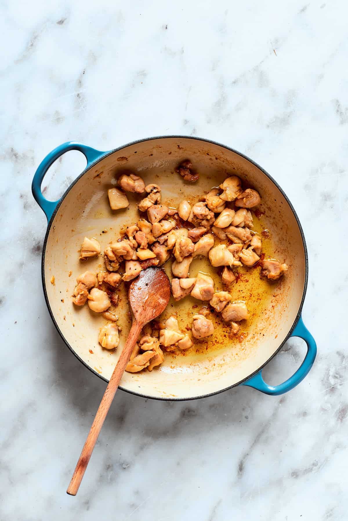 The chicken browns in the pot.