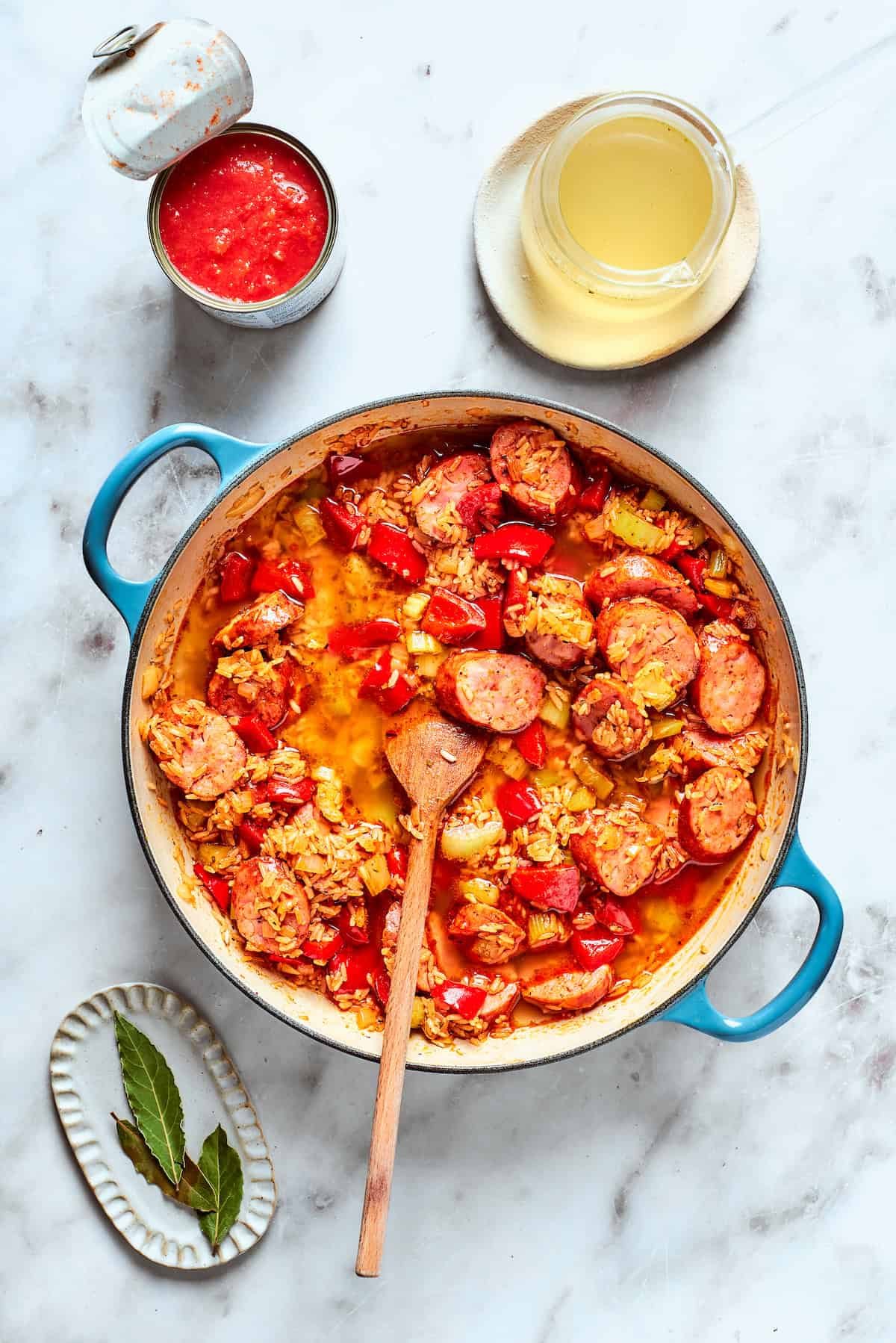 A wooden spoon stirs the jambalaya together.