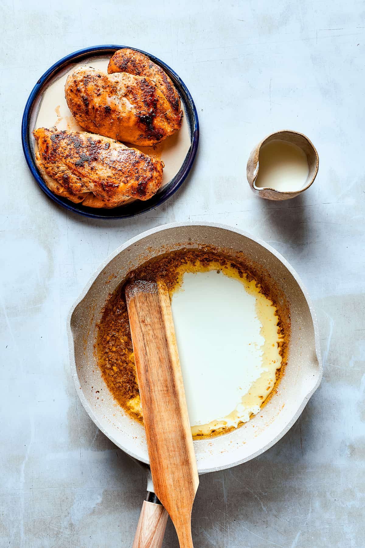 Stirring sauce with a wooden spoon.