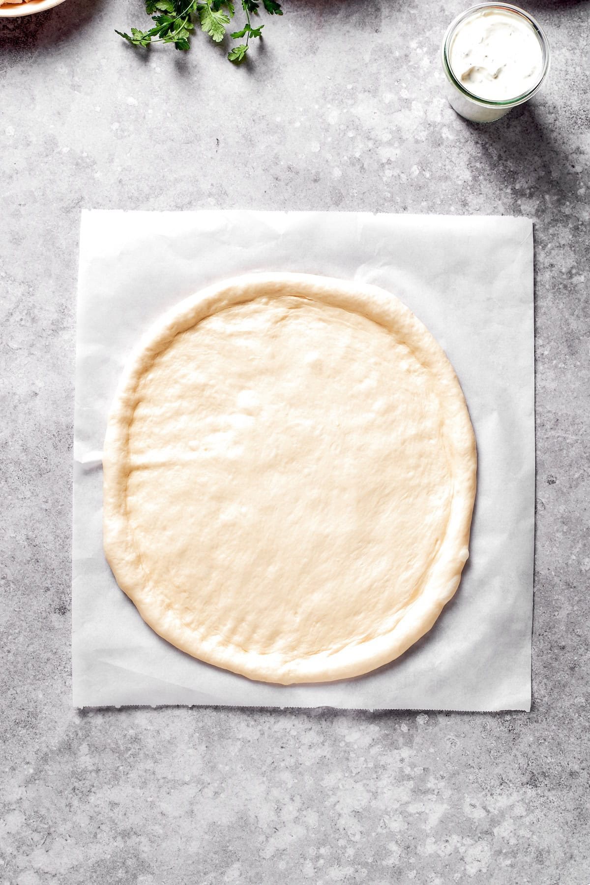 Pizza dough rolled out into a circle.