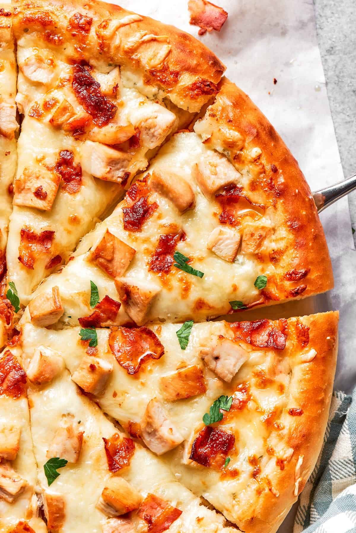 Cut slices of chicken bacon ranch pizza.