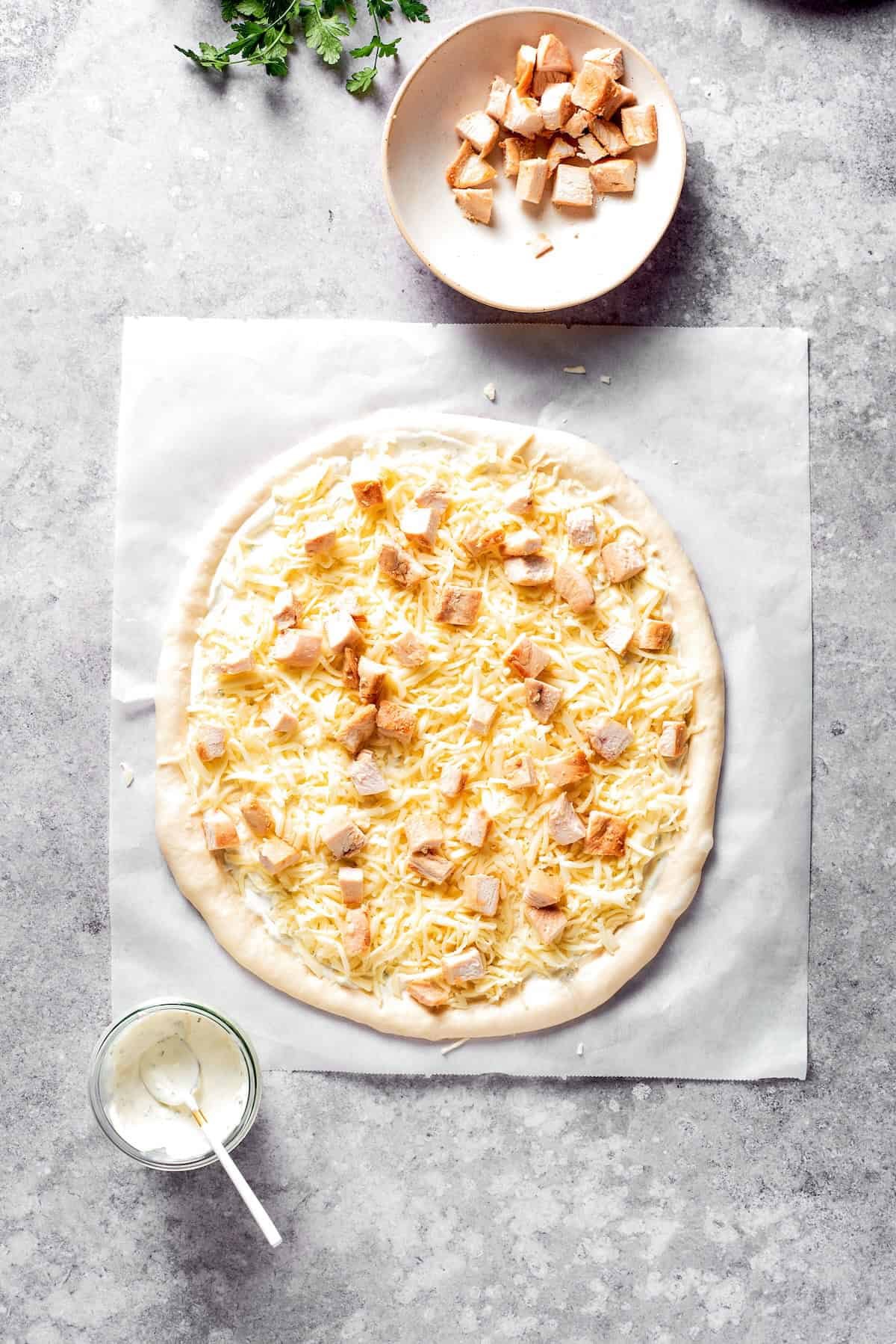 Chicken and shredded cheese added to pizza dough.