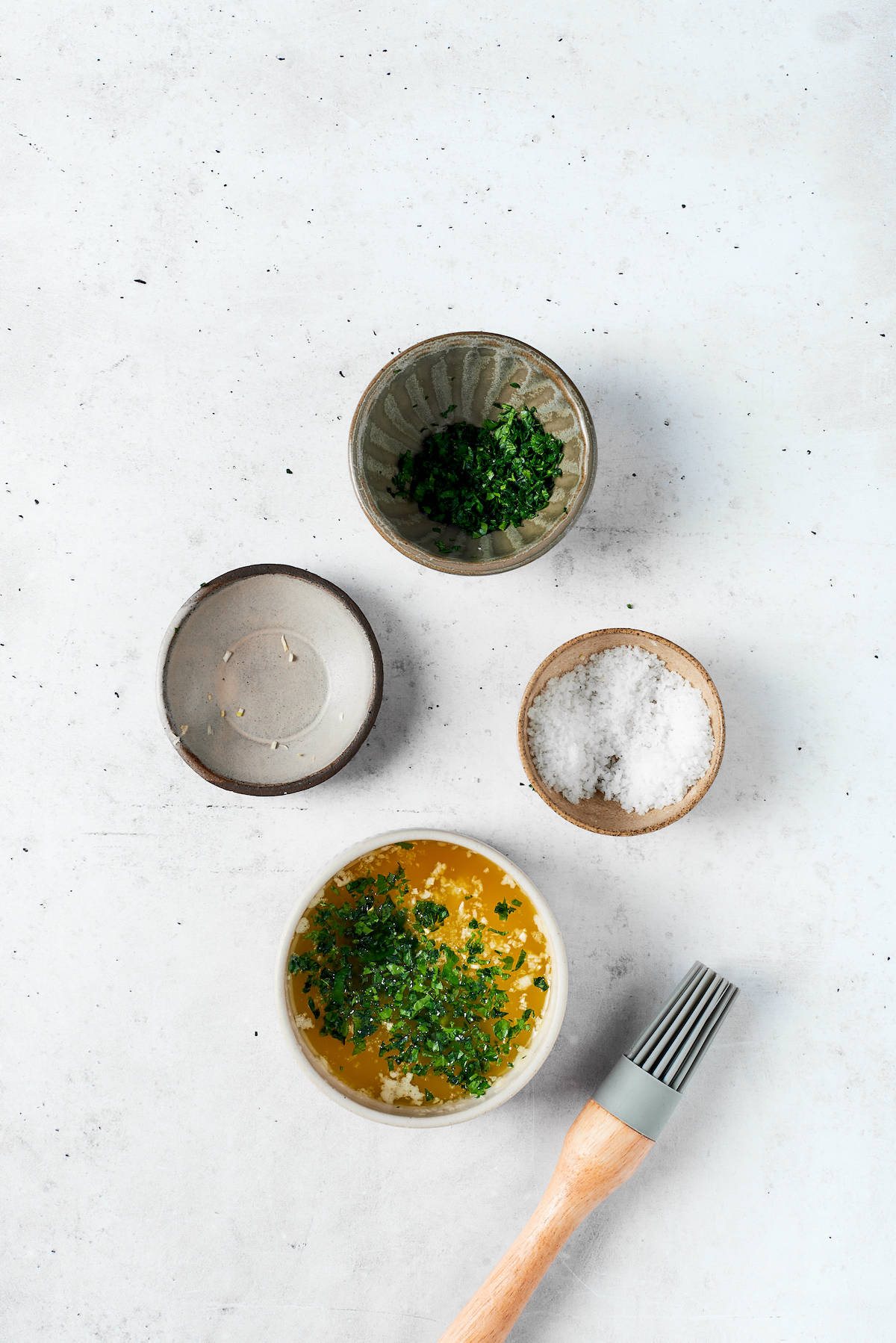 Bowls of melted butter and parsley, salt, minced garlic.