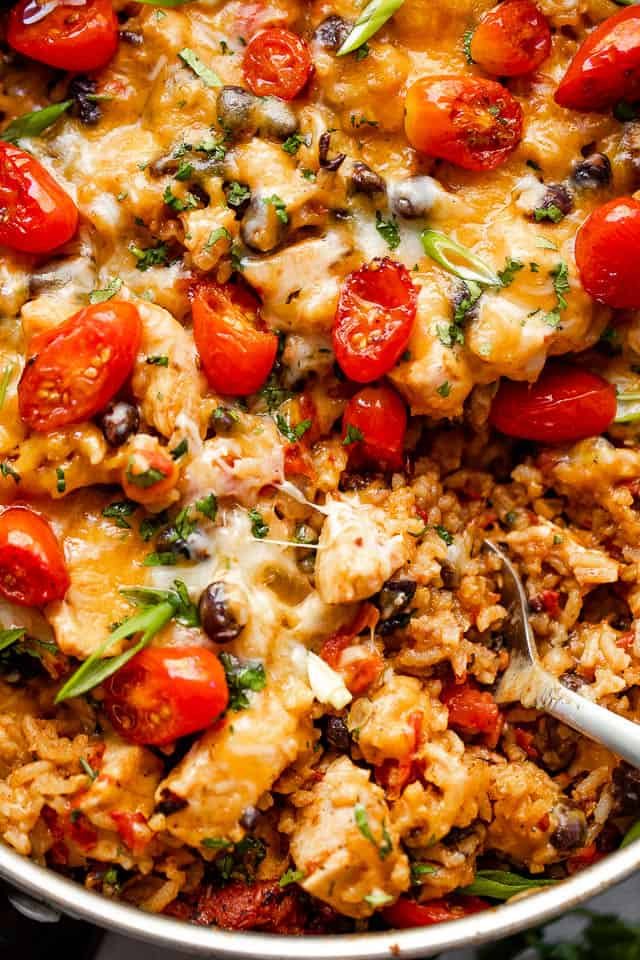 Close up shot of chicken and rice burrito skillet topped with grape tomatoes.