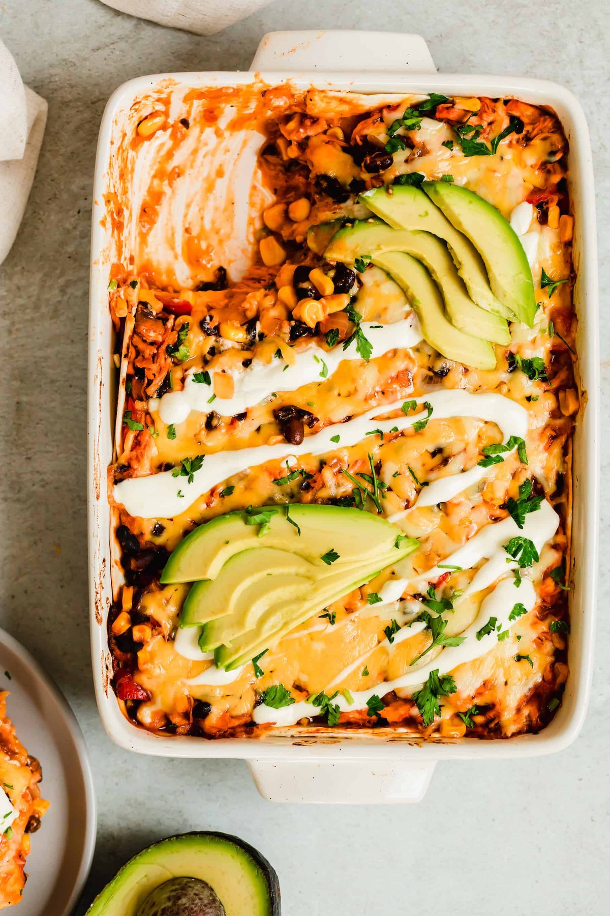 A Casserole in a Pan Next to a Halved Avocado and a Serving Plate