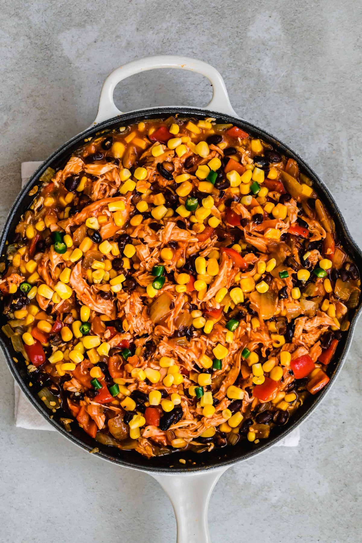 A Large Skillet Filled With A Hearty Chicken Enchilada Casserole