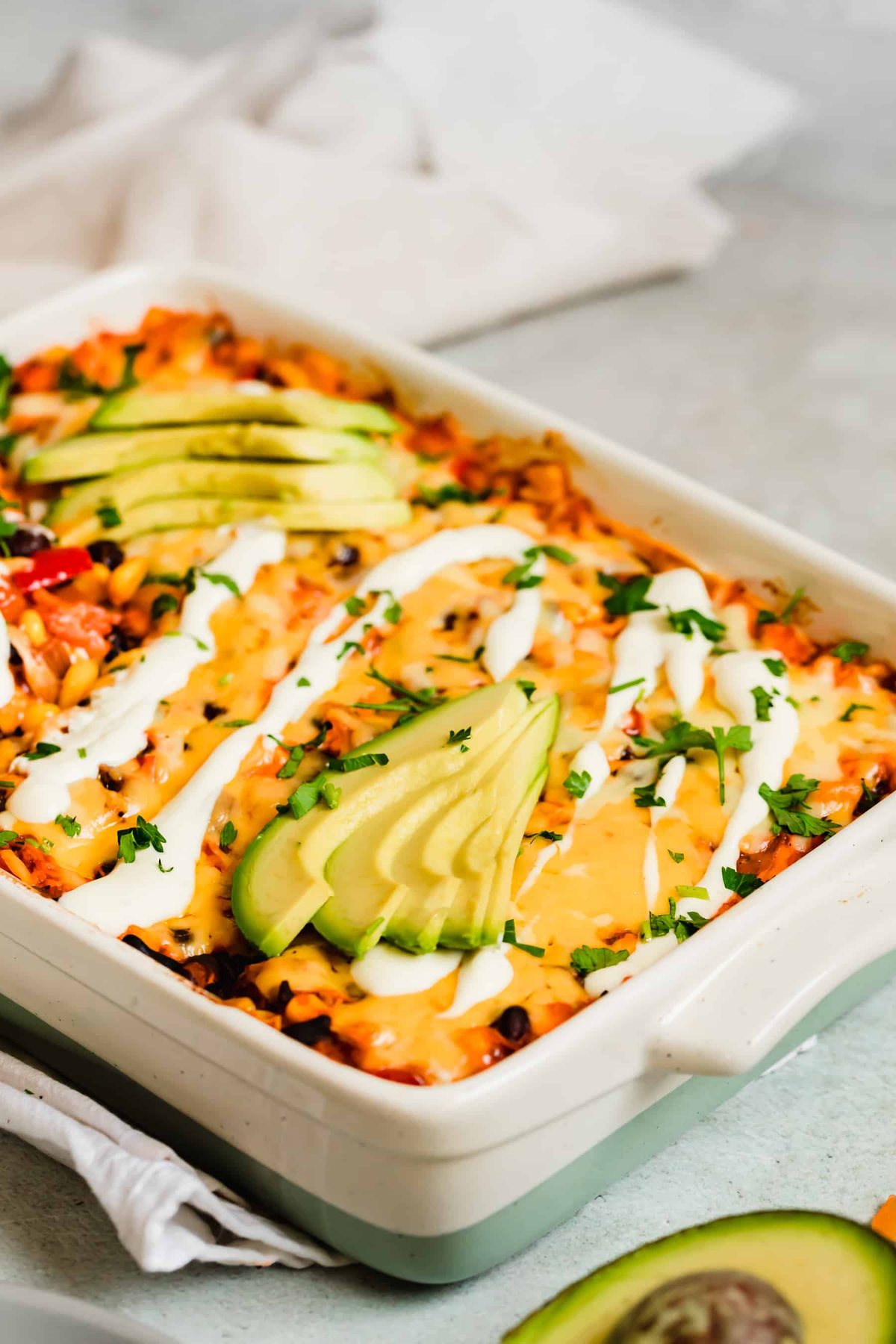 An Enchilada Casserole Topped with Sour Cream and Avocados