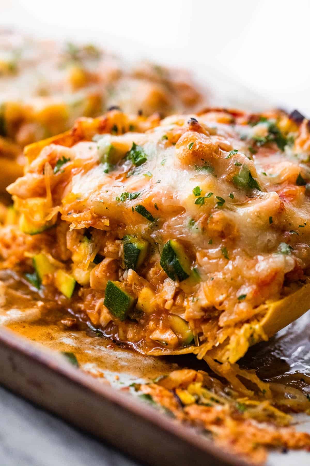 halved spaghetti squash stuffed with chicken enchilada filling and topped with melted cheese