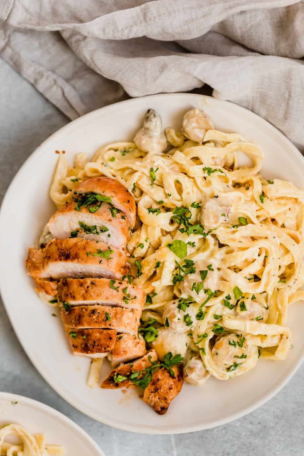 A Bowl of Creamy Fettuccine Alfredo with Mushrooms and Sliced Chicken Breast