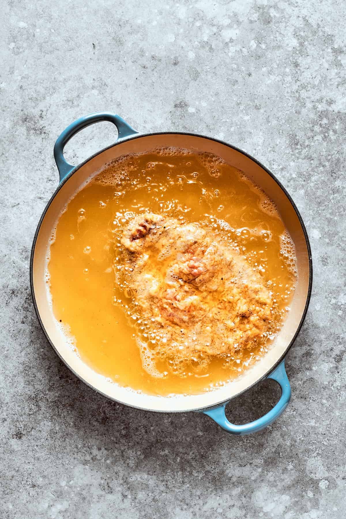 The breaded steak is fried in oil.
