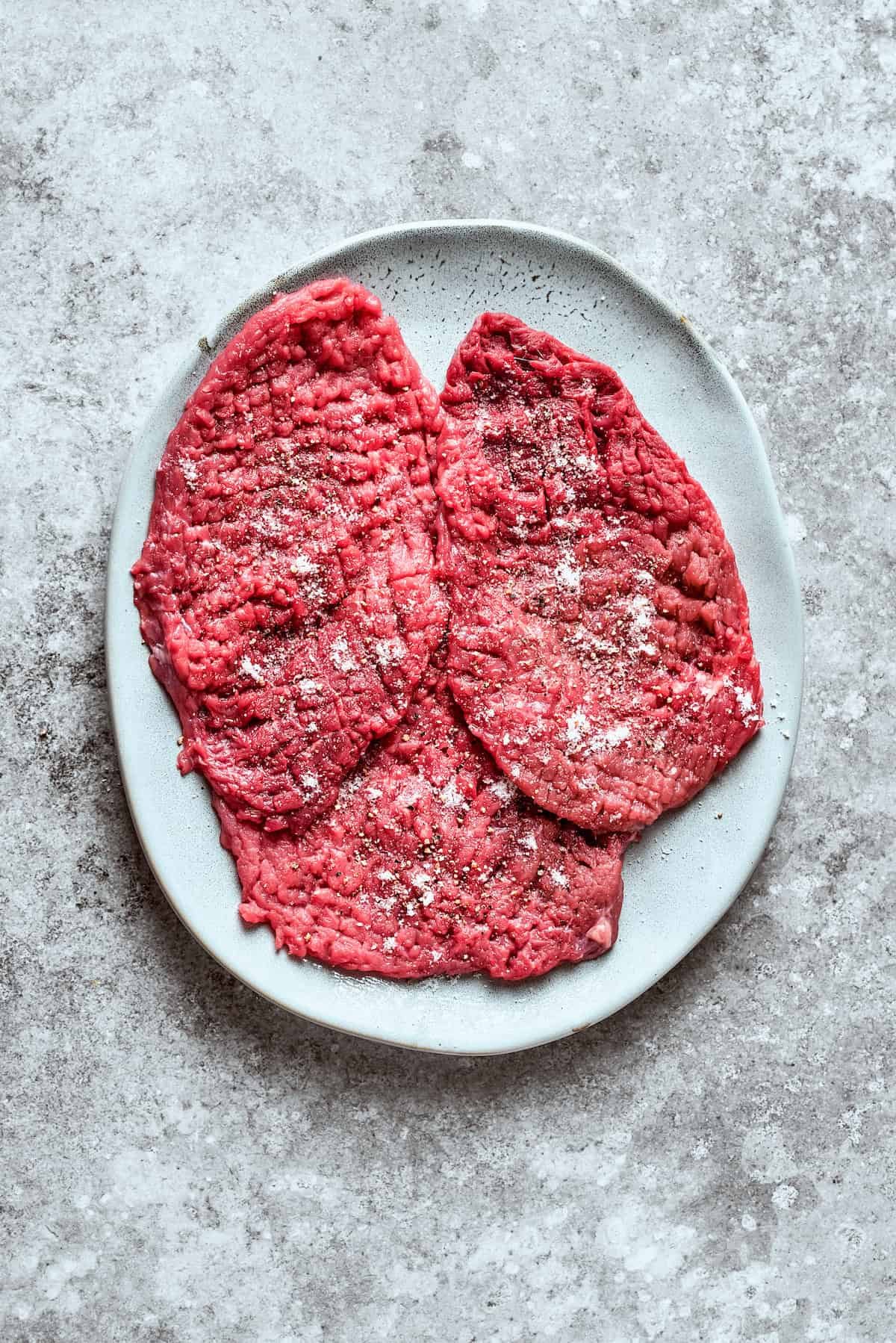Three pieces of cube steak on a plate.