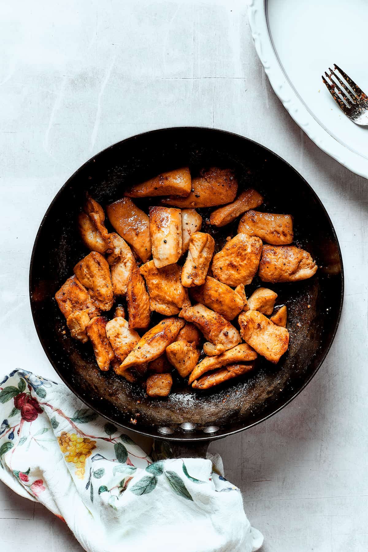 Chicken browning in a skillet.