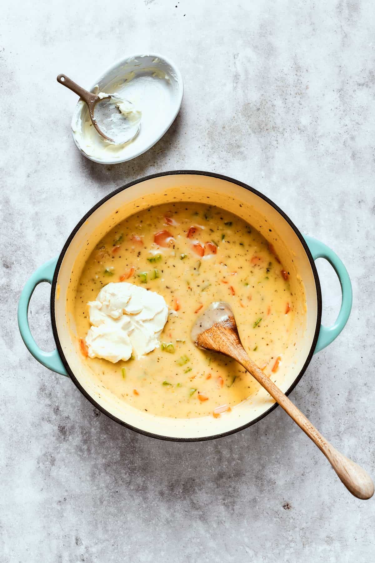 Adding cream cheese to the pot.